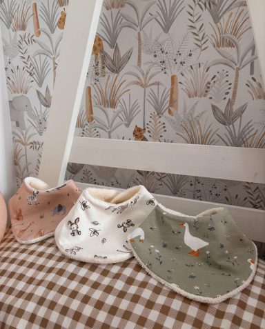 Conjunto de baberos bebé Baberos de bebé en tonos pastel con dibujos de animales sobre fondo claro.